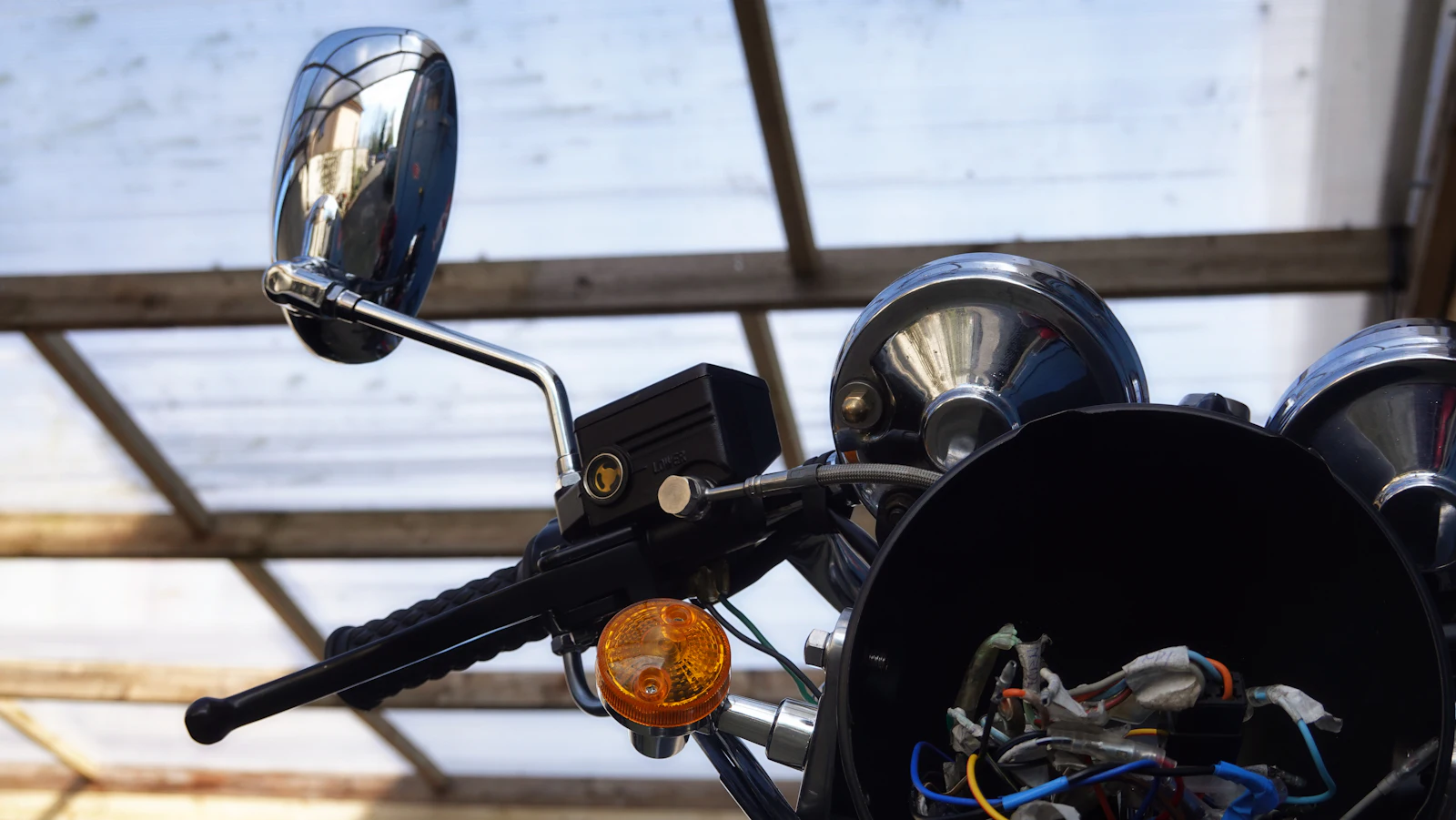 Nahaufnahme von Lenker, Spiegel und Blinker eines Motorrads